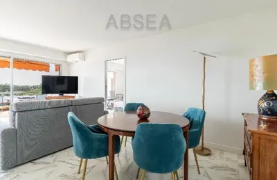 a living room with a table and blue chairs at Nice Absea Belles Terres 1' in Nice