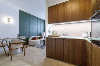 a kitchen with wooden cabinets and a dining room at BERLIOZ - Splendid apartment in Nice city center in Nice