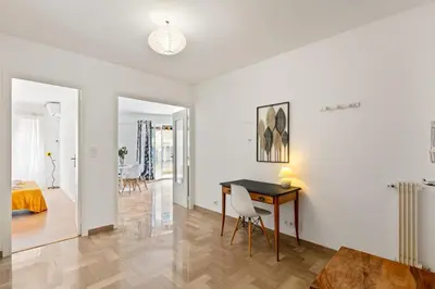 a white apartment with a desk and a bedroom at Suite de Dijon FSHH in Nice