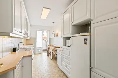 a kitchen with white cabinets and a white refrigerator at Suite de Dijon FSHH in Nice