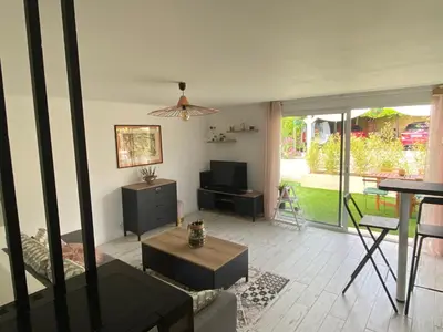 a living room with a couch and a tv and a table at Chez Valentine in Nice