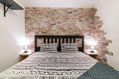 a bedroom with a large bed with a brick wall at MY CASA - STALINGRAD 24 - Cosy loft - Port in Nice