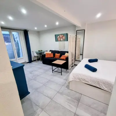 a bedroom with a bed and a couch and a table at Spacious studio full of charm, recently updated in Nice