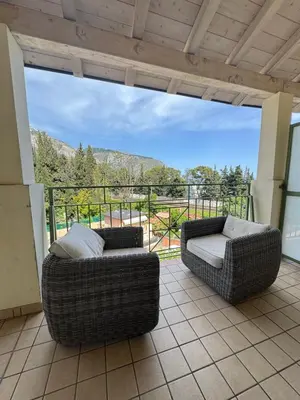 two wicker chairs sitting on a patio with a view at Apartment duplex in Eze sur Mer in Èze