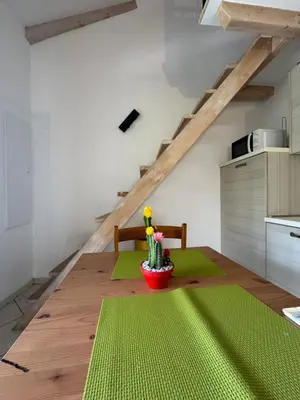 a kitchen with a wooden table with a green rug at Apartment duplex in Eze sur Mer in Èze