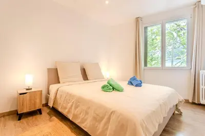 a white bedroom with a large bed with a window at Nice Appartement 4pers à 2 pas de la promenade in Nice