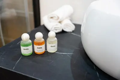 three bottles of essential oils sitting on a table with a vase at Ambiance cosy a la Niçoise in Nice