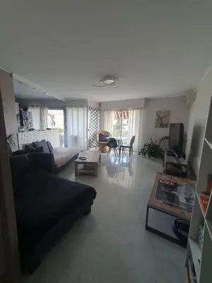 a living room with a couch and a table at Large 2-room bright sea view near airport in Nice