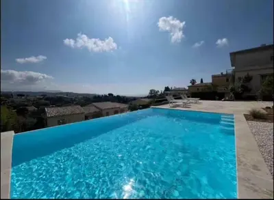 a large blue swimming pool in front of a house at DOMAINE LOU BEL AZUR - Paisible in Saint-Laurent-du-Var
