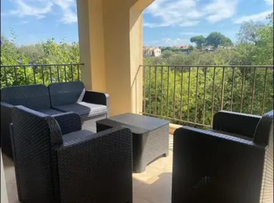 a balcony with wicker chairs and a table with a view at DOMAINE LOU BEL AZUR - Paisible in Saint-Laurent-du-Var