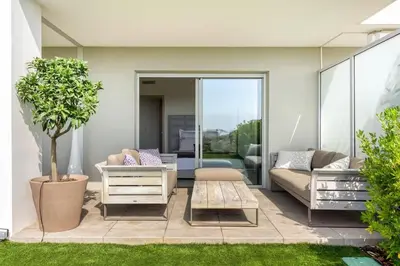 a living room with a couch and a table at Azur Panoramique – Calme Vue Mer proche Nice in Saint-Laurent-du-Var
