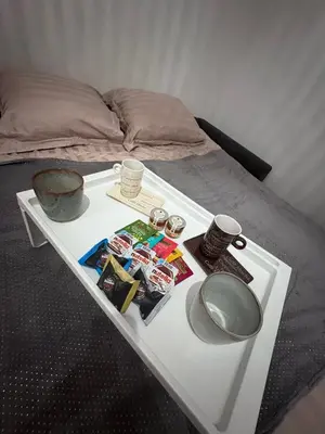 a white table with a tray of food on a bed at Studio cosy Le Vismara in Nice