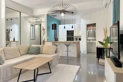 a living room with a white couch and a kitchen at Loft Carré d'or - Wifi, climatisation, 4 personnes in Nice
