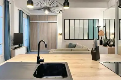 a kitchen with a sink and a living room at Loft Carré d'or - Wifi, climatisation, 4 personnes in Nice