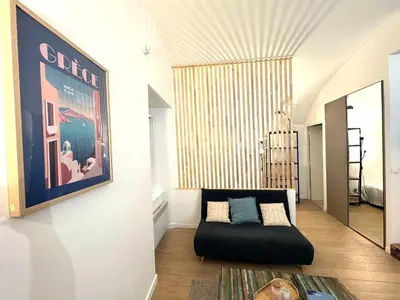 a living room with a couch and a picture on the wall at Studio vieux nice coulee verte in Nice