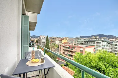 a table on a balcony with a view of a city at Modern Apartment With City View - Happy Rentals in Nice