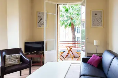 a bedroom with a bed and a couch and a television at Charmant appartement avec terrasse en plein cœur de Nice à deux pas de la mer ! in Nice