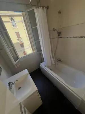a bathroom with a tub and a sink and a window at Charmant appartement avec terrasse en plein cœur de Nice à deux pas de la mer ! in Nice
