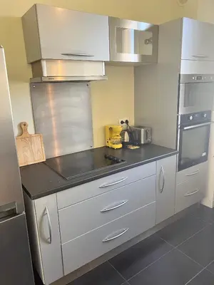 a kitchen with white cabinets and stainless steel appliances at Charmant appartement avec terrasse en plein cœur de Nice à deux pas de la mer ! in Nice