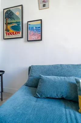 a bedroom with a blue bed with three pictures on the wall at Loft hyper-centre de Nice in Nice