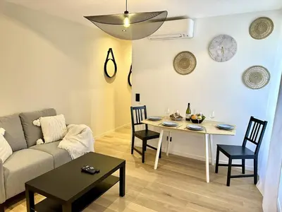 a living room with a couch and a table at Côté Mer - Élégant 3 pièces, Wifi et climatisation in Nice