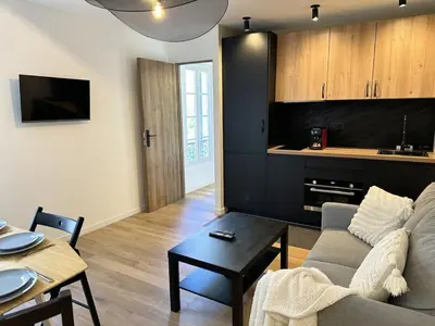 a living room with a couch and a table at Côté Mer - Élégant 3 pièces, Wifi et climatisation in Nice