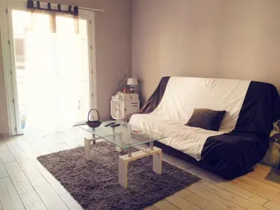 a living room with a couch and a glass table at Joli 2 pièces à 2 min de la plage in Nice