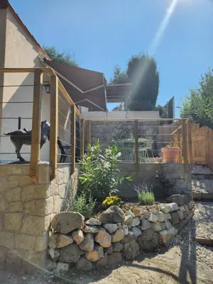 a garden with a fence and a stone wall at maison individuelle in Tourrette-Levens