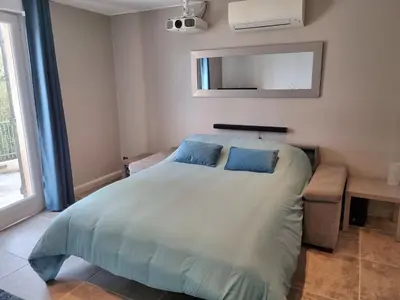 a bedroom with a bed with two blue pillows at Saint-Jeannet Studio apartment near Nice in Saint-Jeannet