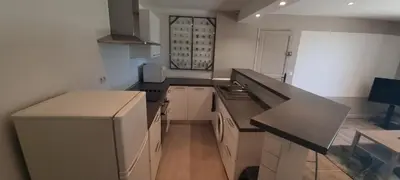a kitchen with white cabinets and black counter tops at Saint-Jeannet Studio apartment near Nice in Saint-Jeannet