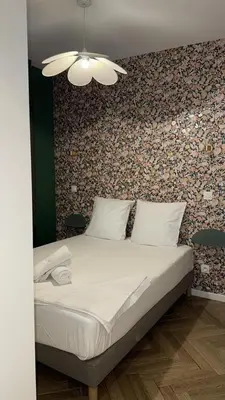 a bedroom with a bed with a wall covered in wallpaper at MOON 25 in Nice