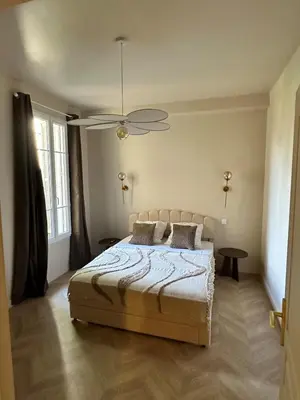 a bedroom with a bed and a ceiling fan at Le Petit Palace in Nice