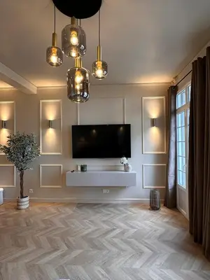 a living room with a flat screen tv on a wall at Le Petit Palace in Nice