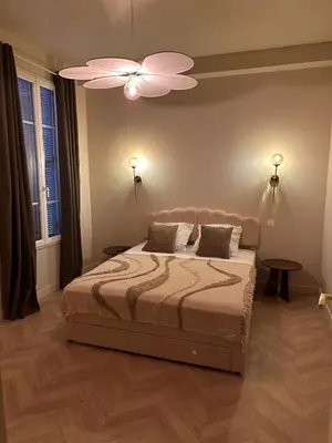 a bedroom with a bed and a ceiling fan at Le Petit Palace in Nice