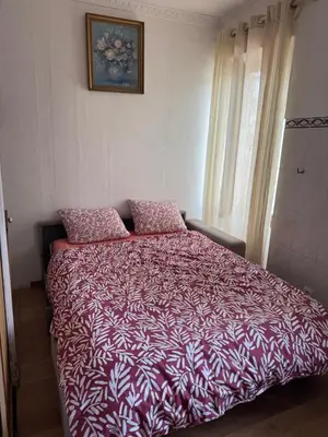 a bed with a red and white comforter in a bedroom at Daghsen in Nice