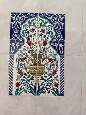 a tile on a wall with a vase on it at Daghsen in Nice