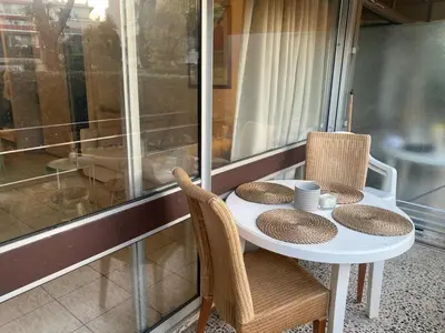 a white table with two chairs and a table with two cups at Studio 50M de la mer in Saint-Laurent-du-Var