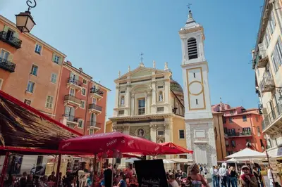 a crowd of people walking around a city with a clock tower at 
