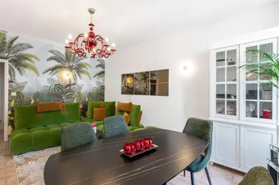 a dining room with a table and green chairs at Appartement 2 chambres proche plage climatisé in Nice