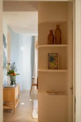a shelf with stacks of towels and a vase at La Rotonde Lympia, vintage chic and design in Nice