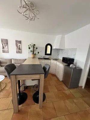 a kitchen with a table and chairs in a room at Maison Lou in Falicon