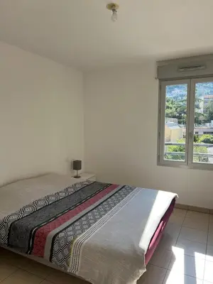 a bed in a white room with a window at Nice 2P quiet, tram, convenient in Nice