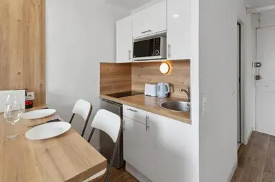 a small kitchen with a wooden table and a sink at L'Opéra - Hypercentre - Cosy - No elevator - Minimalist - Sea in Nice