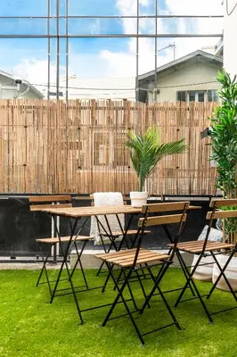 a picnic table and chairs in a yard with a fence at Villa Maska - Studios avec Terrasse proche plage et aéroport de Nice in Nice