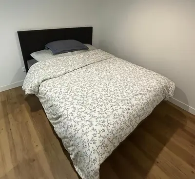 a bed with a black and white comforter in a bedroom at Studio Masséna Nice in Nice