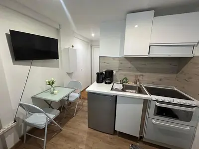 a kitchen with a sink and a table with chairs at Studio Masséna Nice in Nice