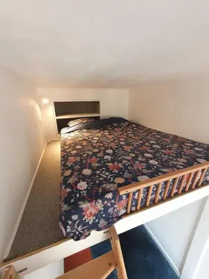 a small bedroom with a bed with a floral bedspread at Superbe appartement niçois in Nice