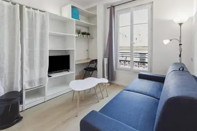 a living room with a blue couch and a tv at Le Citadin - Hypercentre - Cosy - Shopping - WIFI in Nice