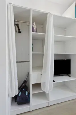 a white book shelf with a tv in it at Le Citadin - Hypercentre - Cosy - Shopping - WIFI in Nice