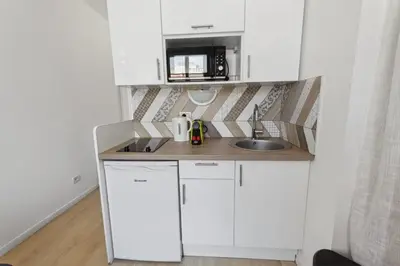 a small white kitchen with a sink and a microwave at Le Citadin - Hypercentre - Cosy - Shopping - WIFI in Nice